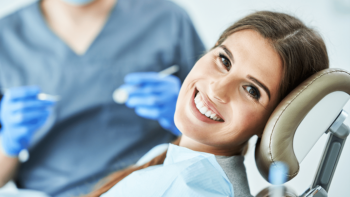 Woman Smiling In Dentist Chair 